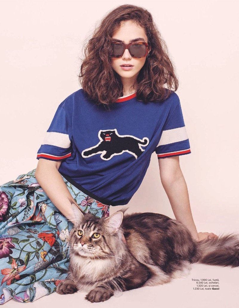 Posing with a cat, Ade Tache models Gucci t-shirt, skirt and sunglasses